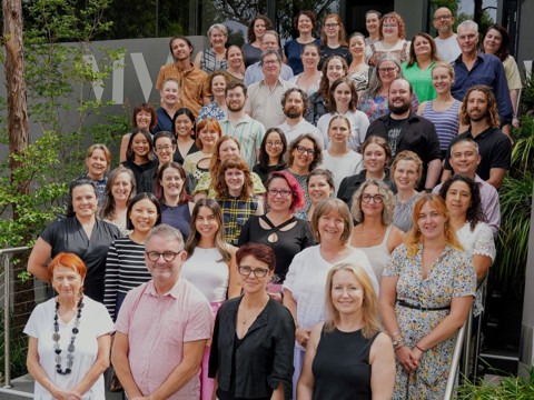 The Musica Viva Australia team gather on a building’s steps, smiling toward the camera.